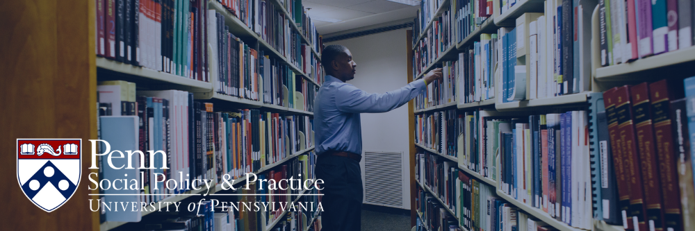Student pulls a book off the shelf in the library